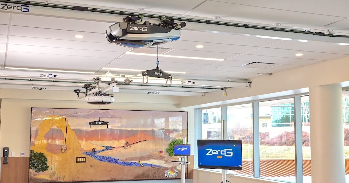 The rehabilitation gym at Craig H. Neilsen Rehabilitation Hospital, with ZeroG and ZeroG 3D body-weight support systems mounted on overhead tracks above a desert-mural training space