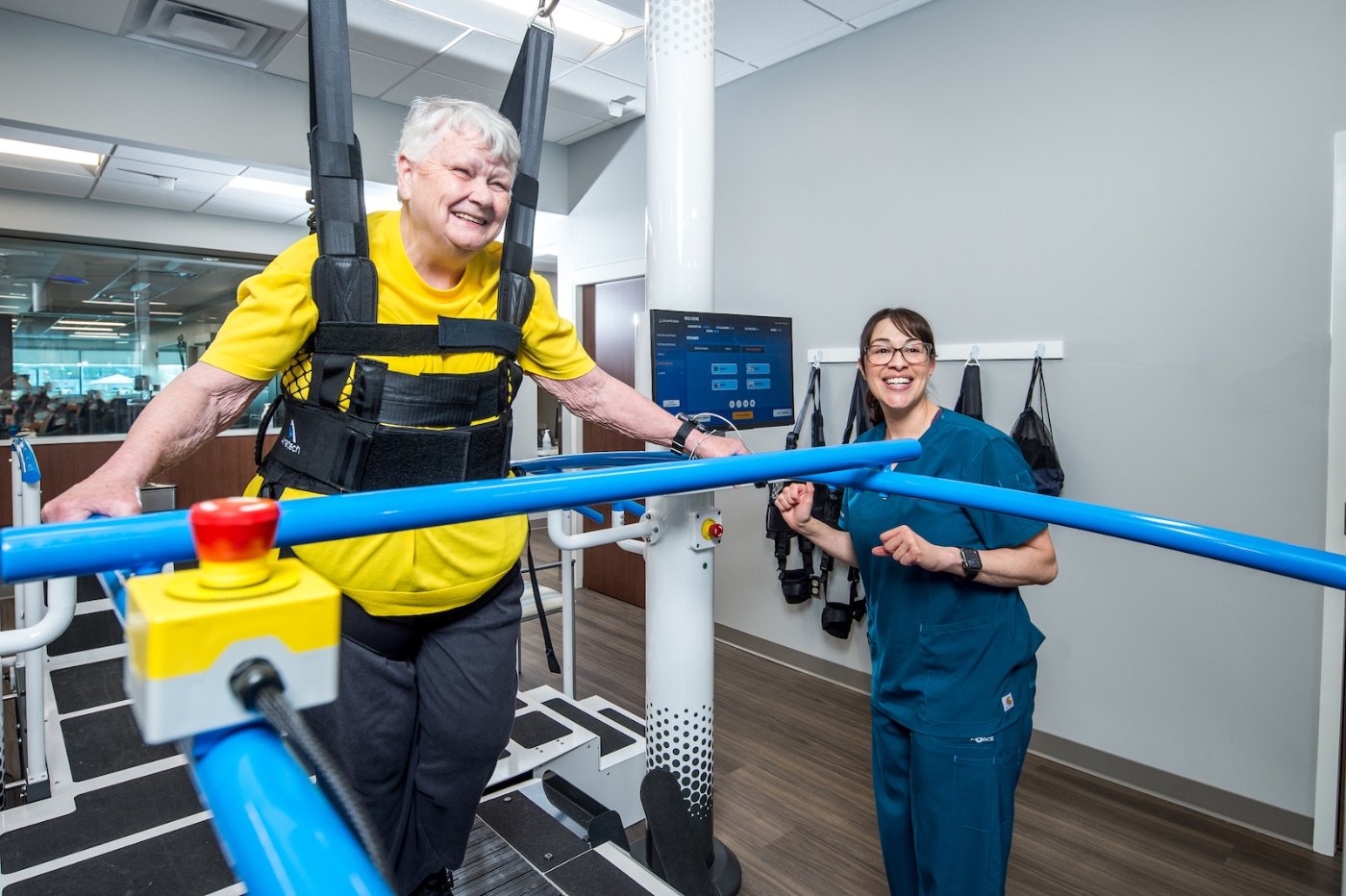 Patient walking in the Ovation harness with a therapist alongside