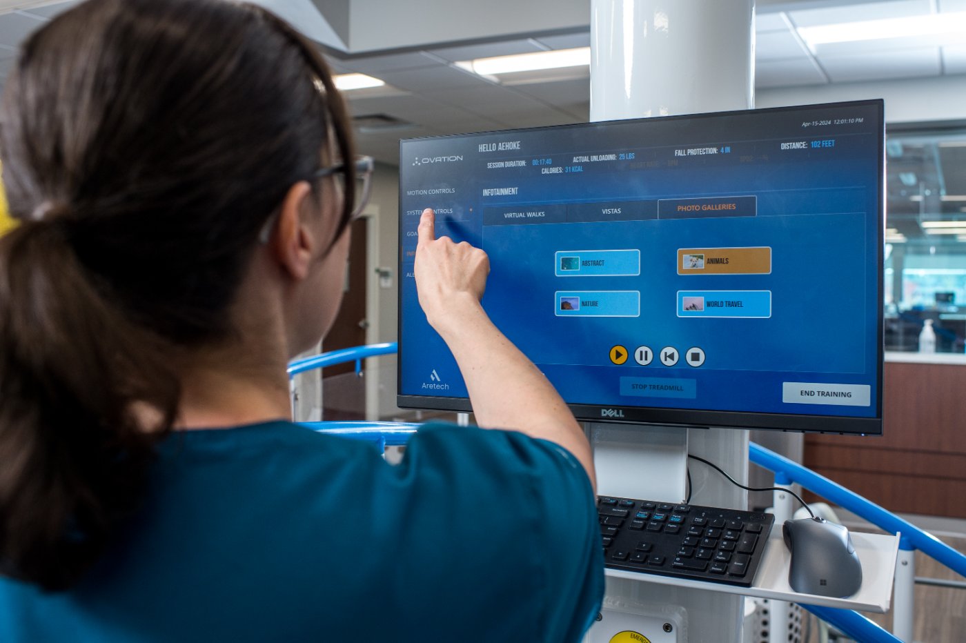 Therapist using the Ovation touchscreen showing training metrics and infotainment options